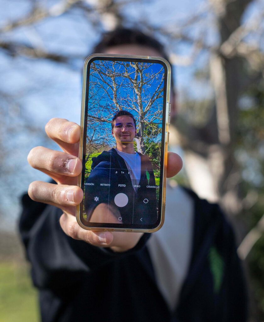 Fotografía en la que aparece la pantalla de un móvil donde se ve en la cámara a Ulises Tuero, dueño de community manager asturias